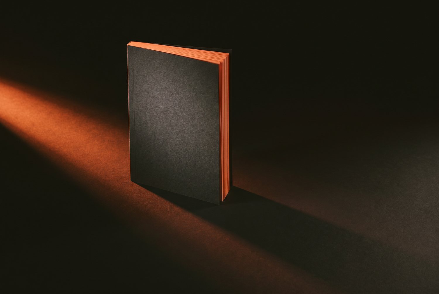 Ein dickes gedrucktes Guide-Heft steht auf dunklem Untergrund, an einer Kante orange angeleuchtet.